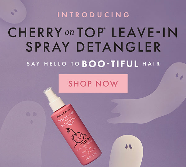 All new Cherry on Top Leave-In Spray Detangler with a pink bottle on a purple background.