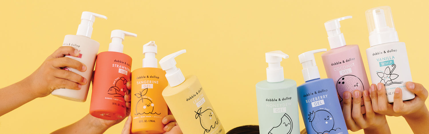 Children holding up bottles of Dabble & Dollop bath gels