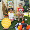 Two children sit by a play tent and plush campfire. One holds up the Dabble & Dollop S'more Bath Set, smiling. A yellow circle reads, "Gentle and safe for sensitive skin.