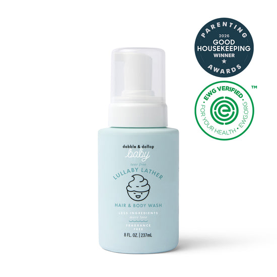 A blue bottle of Dabble & Dollop Lullaby Lather™ Hair & Body Wash appears alongside parenting award and EWG Verified logos. This gentle cleanser, featuring a convenient pump top and an illustrated baby on the label, is the perfect choice for delicate skin.