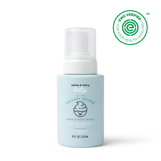 A light blue 8 fl oz bottle of Dabble & Dollop Lullaby Lather™ Hair & Body Wash with a pump top, labeled fragrance-free and gentle for babies. The EWG Verified logo is in the top right corner.