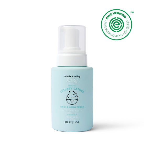 A light blue 8 fl oz bottle of Dabble & Dollop Lullaby Lather™ Hair & Body Wash with a pump top, labeled fragrance-free and gentle for babies. The EWG Verified logo is in the top right corner.