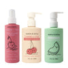 Three Dabble & Dollop bottles: pink Detangler and Conditioner with pump, cream Conditioner, and green All Natural Honeydew Body Wash, each featuring cute fruit illustrations and convenient pump or spray tops.