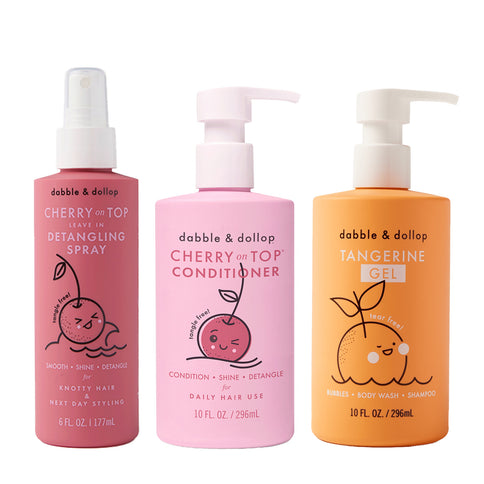 Three Dabble & Dollop bottles—Detangler, Conditioner (both pink), and Tangerine Gel (orange)—stand side by side. Each features cute fruit cartoons and simple labels.