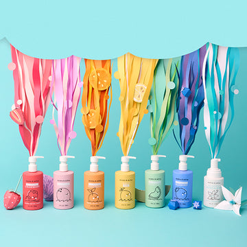 Colorful bottles of 3-in-1 bubble bath, body wash and shampoo with pump dispensers on a light blue background