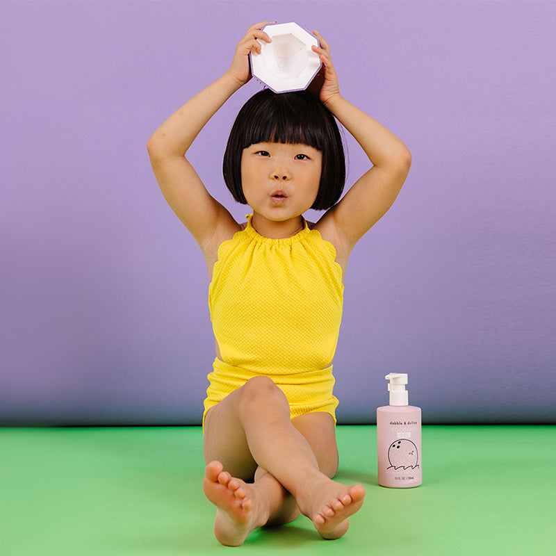 Little girl sitting with coconut gel and paper coconut