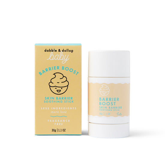 The Barrier Boost Skin Barrier Soothing Stick by Dabble & Dollop is shown next to its pale yellow and blue box. Packaging highlights include "Skin Barrier Soothing Stick" and "Fragrance Free.