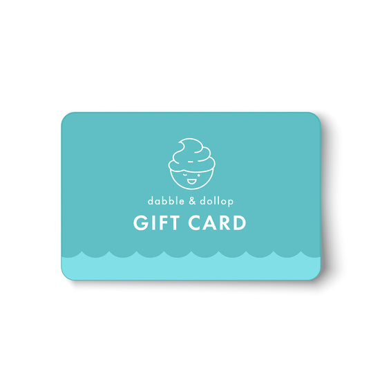 A turquoise Dabble & Dollop Gift Card e-gift, with a smiling swirl line drawing and wave pattern, is perfect for gifting plant-based products. Text reads dabble & dollop GIFT CARD on a white background.