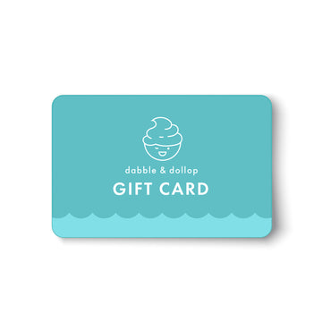 A turquoise Dabble & Dollop Gift Card e-gift, with a smiling swirl line drawing and wave pattern, is perfect for gifting plant-based products. Text reads dabble & dollop GIFT CARD on a white background.