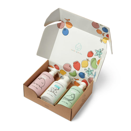 The Dabble & Dollop A Day at the Beach Bath Bundle includes three pastel bottles—Honeydew Melon, Coconut, and Vanilla Whip—that work as Shampoo, Bubble Bath, and Body Wash in a fruit-decorated box.