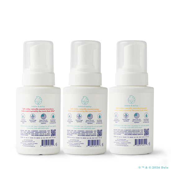 Three white pump-top bottles of Dabble & Dollop's Dole Whip® Foaming Body Wash Bundle are arranged together, each with a baby icon, colorful scent names—strawberry, orange, and peach—and hypoallergenic labels showing product info.