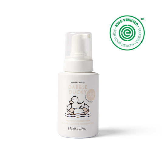 The white bottle of Dabble & Dollops Fragrance Free Foaming Infant Wash, ideal for sensitive skin, has a cartoon duck in a rubber ring on the label. A green HWG Verified seal is on the top right corner. This 8 fl oz / 237 ml bottle contains gentle, natural infant wash.