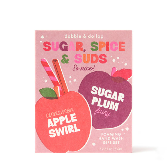 A festive gift box from Dabble & Dollop featuring colorful illustrations—a red apple labeled “Cinnamon Apple Swirl” and a purple plum labeled “Sugar Plum Fairy.” The text above reads “Sugar, Spice & Suds Foaming Hand Wash Gift Set.” This seasonal set offers natural origin fragrances for a delightful hand washing experience.