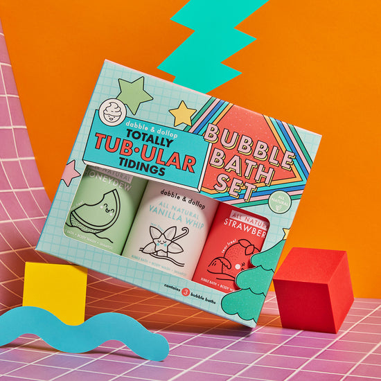 The Dabble & Dollop Totally Tub-ular Tidings Bubble Bath Set features playful bottles of Strawberry, Honeydew & Vanilla scents—perfect for gifting. Each bottle sports fun illustrations and the set comes in a vibrant, festive box.