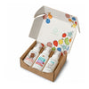 An open cardboard box reveals three Dabble & Dollop Bath Gift Sets—ideal for kids’ bath time or as a thoughtful gift—featuring colorful fruit illustrations on the inside of each lid. Each bottle is labeled with one of the following scents: Candy Cane Chocolate, Dole Whip Strawberry, and Dole Whip Pineapple. The gentle formulas are specially designed for sensitive skin.