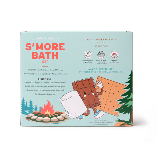 A box labeled S'more Bath Set by Dabble & Dollop features playful cartoon chocolate and marshmallow characters in a forest, with bath bomb directions and kids' bath set benefits printed on the front.