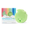 A green, smiling honeydew-shaped Sponge Pop™ by Dabble & Dollop sits by its colorful box, featuring a natural honeydew scent, built-in kids body wash, and a biodegradable sponge.