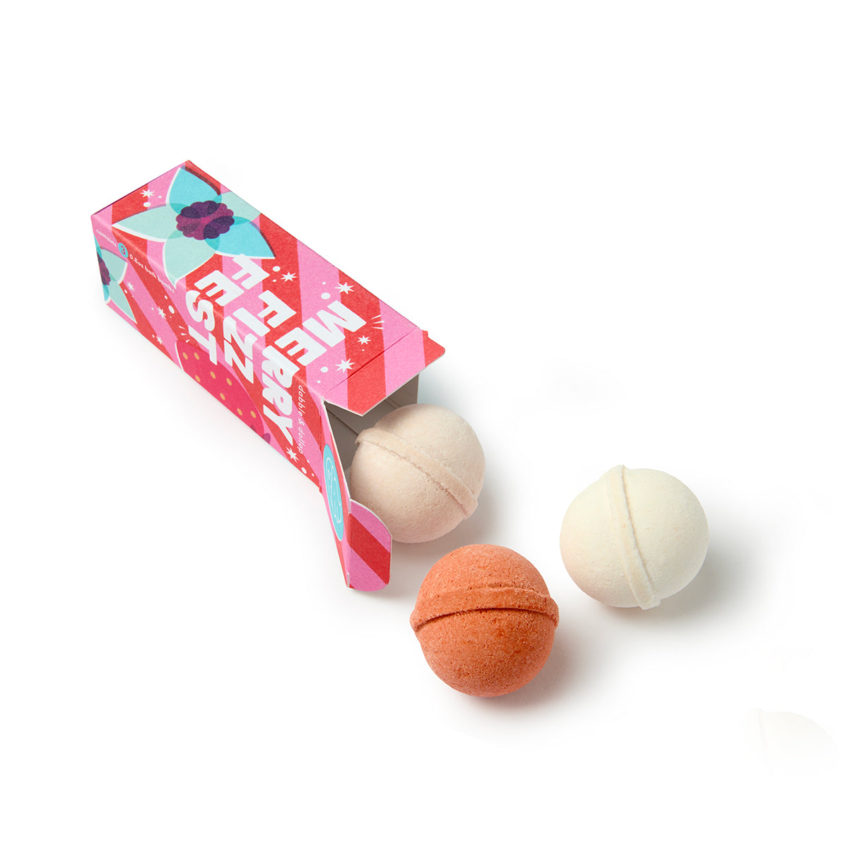 A vibrant rectangular box adorned with retro designs, the Dabble & Dollop Merry Fizzfest Mini Drops Stocking Stuffer dispenses three round bath bombs—one orange and two white—onto a white surface, making it a cheerful holiday gift or stocking stuffer.