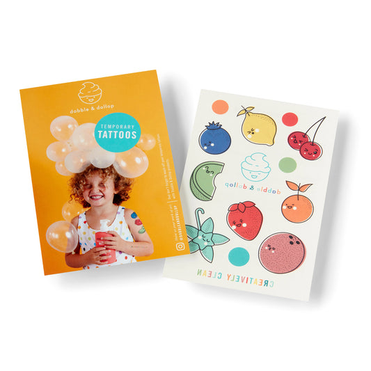 The Dabble & Dollop Original Bubble Bath Bundle features two sheets: one with a smiling curly-haired child and bubbles, cup in hand, on an orange backdrop; the other with cheerful fruit and bubble temporary tattoos.