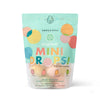 A vibrant, resealable pouch labeled “Dabble & Dollop Tropical Mini Bath Bombs” features pastel circles, fruit art, and highlights coconut, guava, mango, and kiwi scents made with natural ingredients for kids' baths.