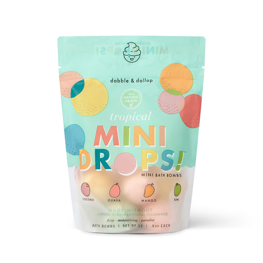 A vibrant, resealable pouch labeled “Dabble & Dollop Tropical Mini Bath Bombs” features pastel circles, fruit art, and highlights coconut, guava, mango, and kiwi scents made with natural ingredients for kids' baths.